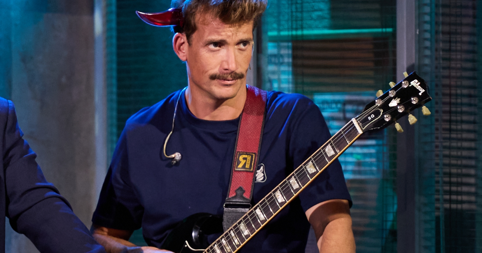 Grison tocando la guitarra en La Revuelta con la camiseta del logo del mono de Are Monkey